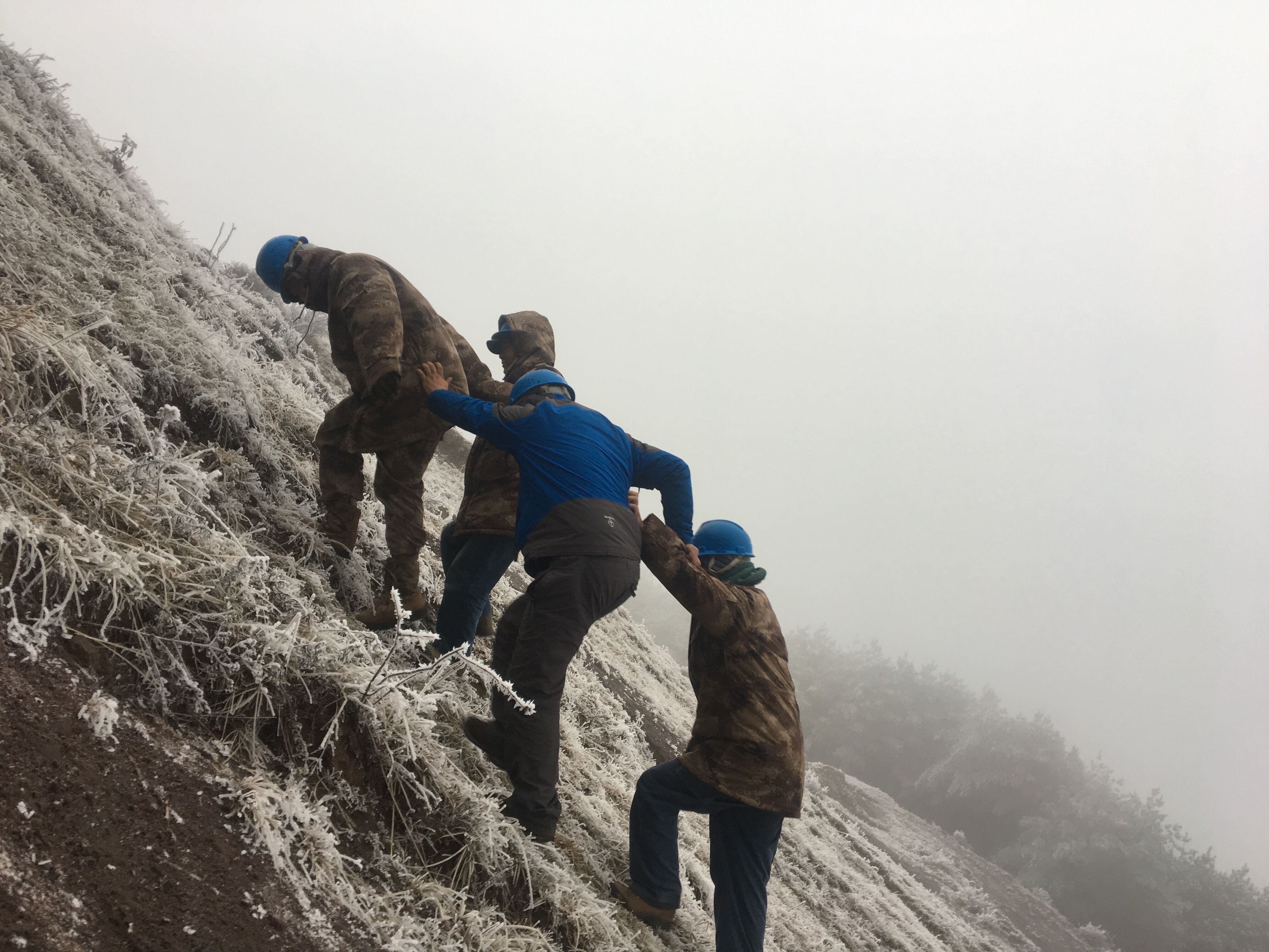 互相攙扶，勇登高峰。（李健攝）